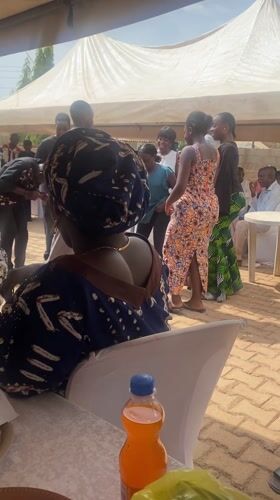 Community celebration with dancing under tent in Kura, Nigeria