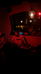 Female DJ performs at dimly lit nightclub early morning