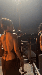 Women in evening wear stroll Belgrade waterfront promenade at night