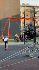 Children play on swings and equipment at Ufa playground
