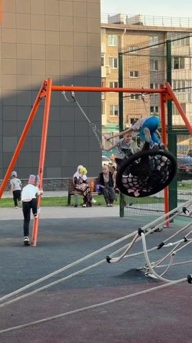 Children play on swings and equipment at Ufa playground