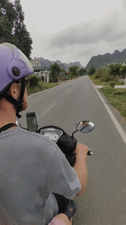 Moped rider with phone mount travels Hải Phòng road