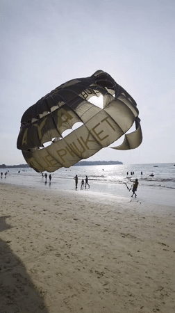 Parasailing operator sets up equipment on sunny Phuket beach