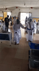 Religious ceremony with white-robed congregation in Lokoja hall