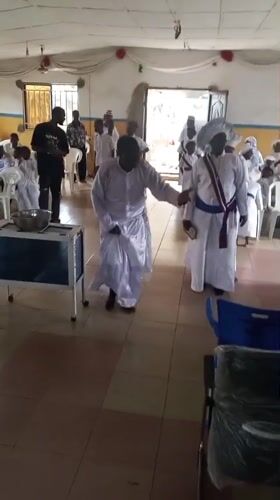 Religious ceremony with white-robed congregation in Lokoja hall
