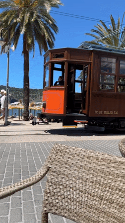 Vintage tram passes coastal cafés in Sóller, Spain