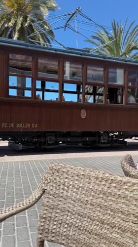 Vintage tram passes coastal cafés in Sóller, Spain