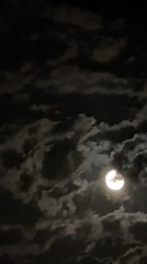 Witnesses capture moon partially veiled by passing clouds