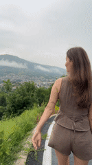 Woman walks mountain road amid scenic Bulgarian countryside