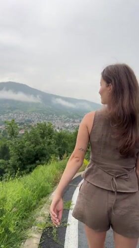 Woman walks mountain road amid scenic Bulgarian countryside
