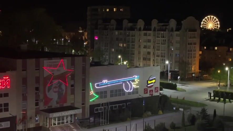 Building displays cycling military neon projections in Zelenogradsk