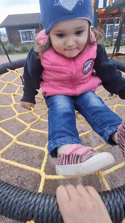 Toddler plays at Timmolovo playground during overcast afternoon