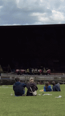 Brass band in red uniforms performs outdoor concert in London