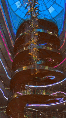 Witnesses capture grand atrium with golden chandelier, glass elevators