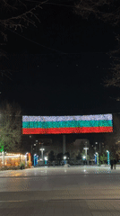 Nighttime festivities in Burgas square feature flag displays, music