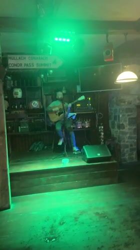 Acoustic guitarist performs during dinner service at Dublin pub