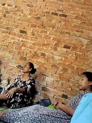 Families resting together inside a bare brick room in Giri Mulyo