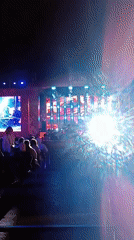 Nighttime concert documented with illuminated Baku landmark visible