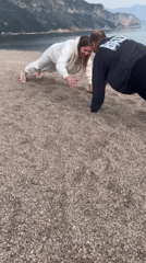 Family conducts beach workout session with toddler participation