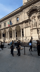 Pedestrians gather on classical Milan street during afternoon