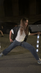 Woman performs street splits during nighttime in Sofia, Bulgaria