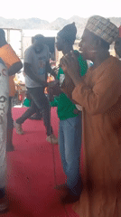 Men perform on red-carpeted outdoor stage