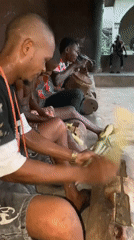 Men gather for traditional sugar cane processing and drumming in Nigeria