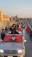 Political vehicle convoy rolls through central Quetta with portraits on display