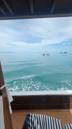 Longtail boat crossing turquoise waters off Ko Samui