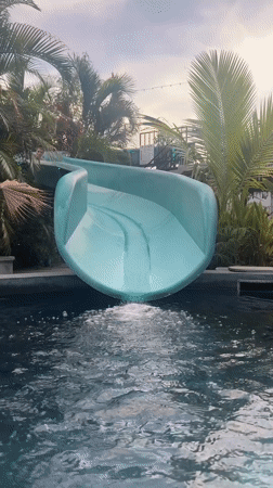 Person enjoys water slide at Thai swimming pool