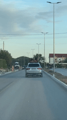 Two people ride on Mercedes roof in Montenegro village
