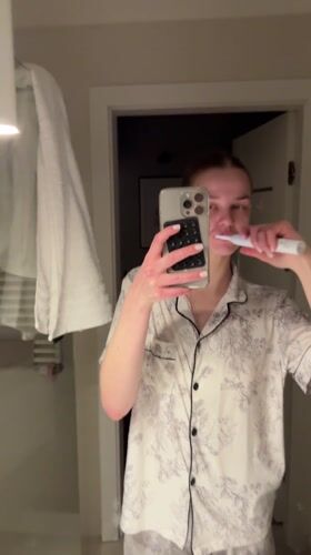 Woman records evening tooth-brushing routine in Warsaw bathroom