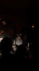 Costumed patrons gather at dimly lit Paris bar