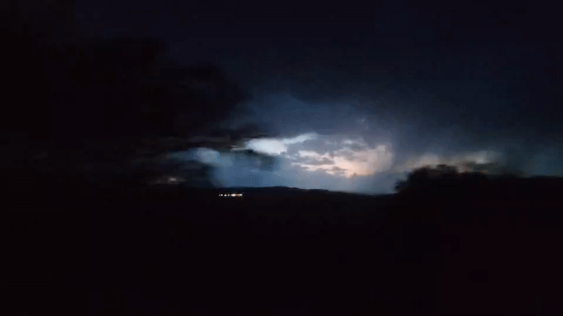 Lightning storm unfolds across a dark landscape at night