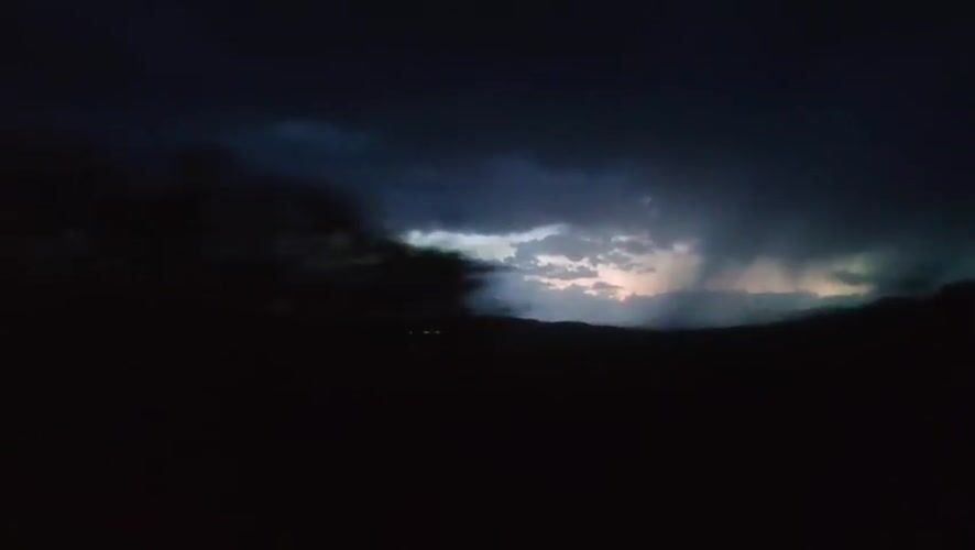Lightning storm unfolds across a dark landscape at night