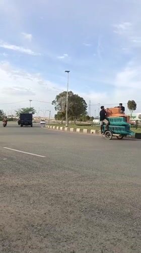 Street activity along a paved road in Meureudu, Indonesia