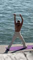 Woman practices yoga by water in Sirius, Russia
