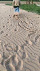 Person documents sandy terrain and sand messages in Belarus