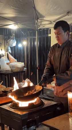 Wok cooking over open flame at an LA outdoor food stall
