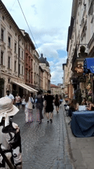Rainy afternoon foot traffic on a historic Lviv cobblestone street