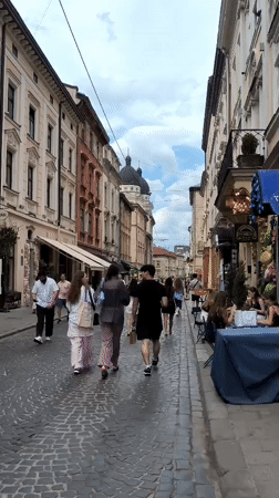 Rainy afternoon foot traffic on a historic Lviv cobblestone street