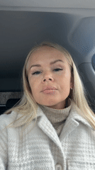 Woman adjusts clothing while seated in car driver's seat