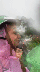 Smiling motorbike passenger enjoys rainy ride in Vietnam