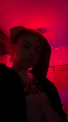 Person photographed in red-lit room holding candy wrapper in Buenos Aires