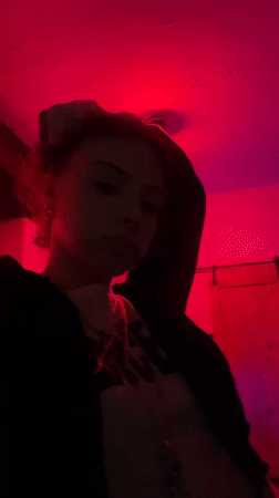 Person photographed in red-lit room holding candy wrapper in Buenos Aires