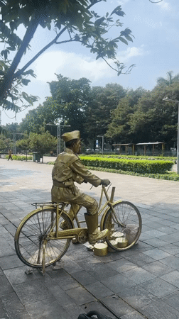 Gold-painted street performer poses as living statue in Jakarta