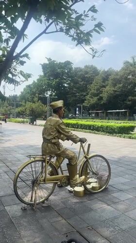 Gold-painted street performer poses as living statue in Jakarta