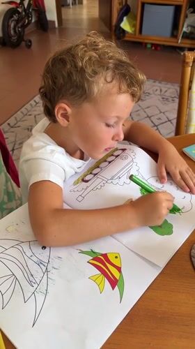 Young boy coloring with green marker in Kuta Selatan