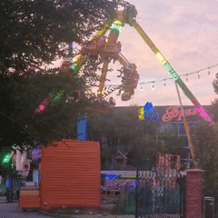 Aktobe amusement park at dusk, rides glowing against the evening sky