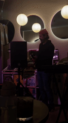 Bearded guitarist performs at dimly lit indoor venue